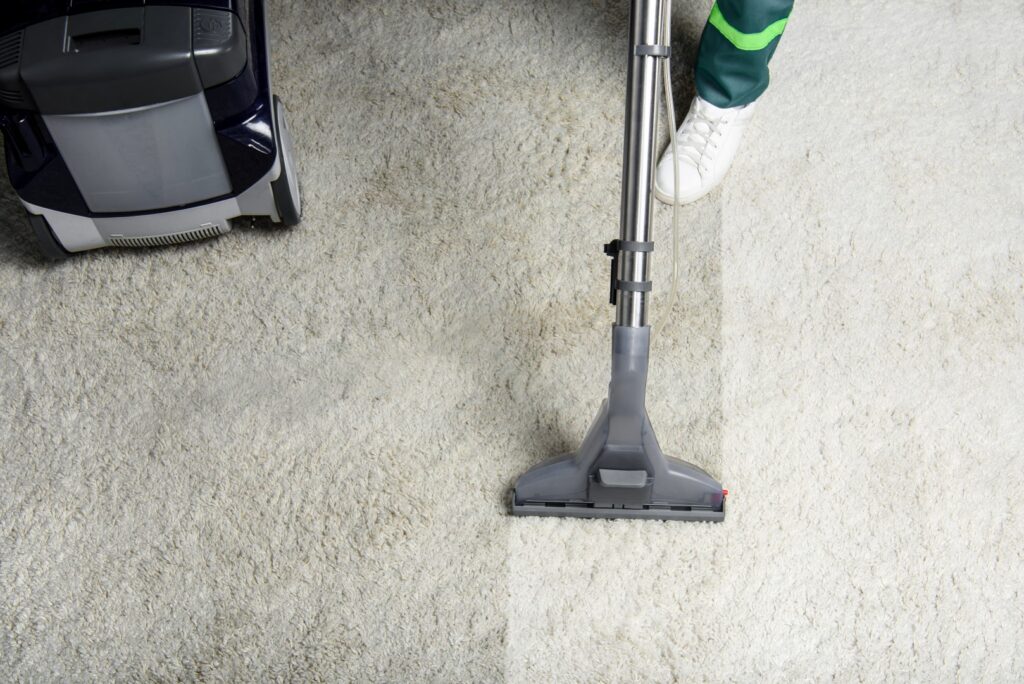 Technician using professional carpet cleaning equipment on a beige carpet